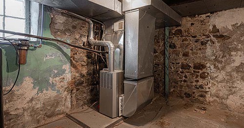Image; a furnace that's past its prime in a basement.