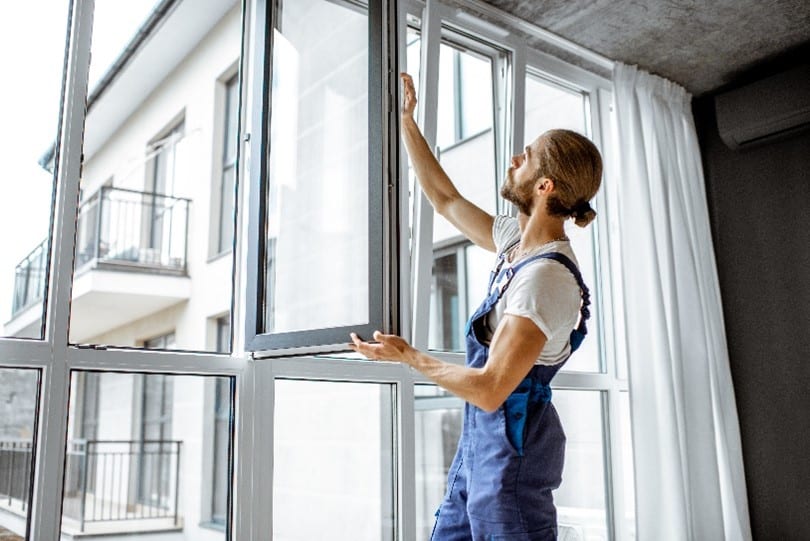 man measuring window